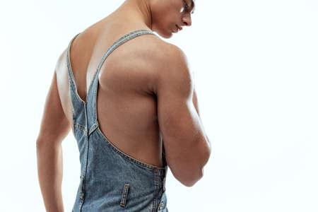Cropped image of young sportive shirtless man in jeans posing isolated on white studio background.の写真素材