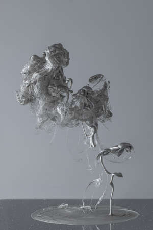 Black and white image. Explosion of ink, fluid on bw studio background with copyspace for ad