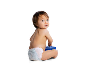 Portrait of little boy, baby, child in diaper playing with toy safe box isolated over white studio background. Childhood conceptの写真素材