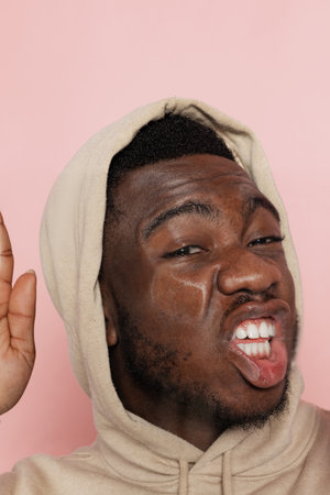 Young handsome man, student leaned against transparent glass isolated on pink studio background. Close-upの写真素材