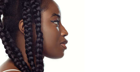 Close-up portrait of young beautiful african girl with afro hairdo isolated over white studio...