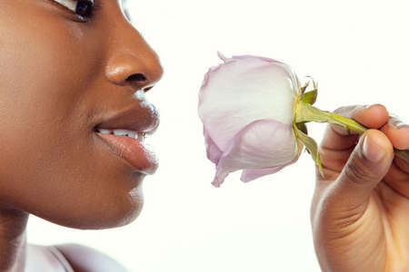 Close up face of young african woman with well-kept skin isolated on white studio background....