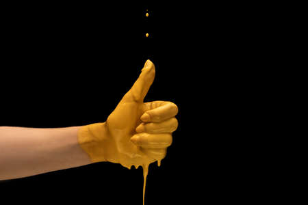 One painted human hand gesturing isolated on dark studio background. Concept of human relation, symbolism, culture and historyの写真素材