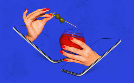 Female hands with cocktail glass sticking out phone screens isolated on bright blue neon background....