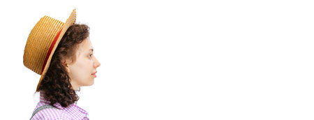 Profile view of young beautiful curly girl wearing plaid shirt and hat isolated on white background. Flyer, poster, bannerの写真素材