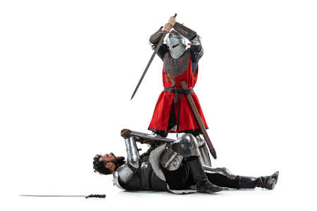 Full-length portrait of two medieval warriors, knights fighting isolated over white studio backgroundの写真素材