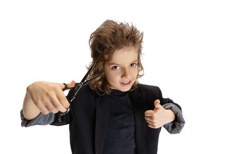 Great hairstyle. Portrait of liitle boy, kid in image of stylish hairdresser, barber isolated on white studio background. Concept of occupation, modern specialists, childhoodの写真素材