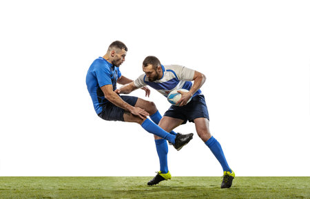 Dynamic portrait of male rugby players playing rugby football on grass field isolated on white background. Sport, activity, health, hobby, occupations conceptの写真素材