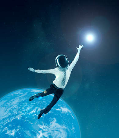Conceptual creative artwork with businessman in helmet flying at outer space on sky background....