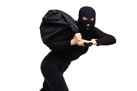 Portrait of young anonymous person wearing black outfit and balaclava isolated on white background....