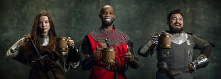 Creative collage with happy men and woman in image of medieval warriors holding big mugs of frothty...