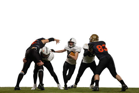 Fight for ball. Group of young sportive men, professional american football players in sports uniform and equipment in motion isolated on white background. Concept of super bowlの写真素材