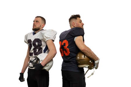Portrait of two professional american football players in sports uniform and helmets equipment...