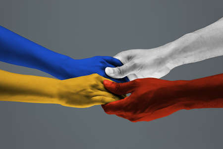 Support. Painted hands of peoples crows in touch isolated on dark studio background. Concept of...
