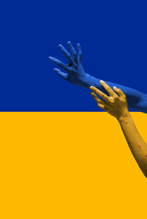 Painted in blue-yellow colors of Ukrainian flag hands gesturing isolated on bright background. Concept of help, support. Stand for Ukraineの写真素材