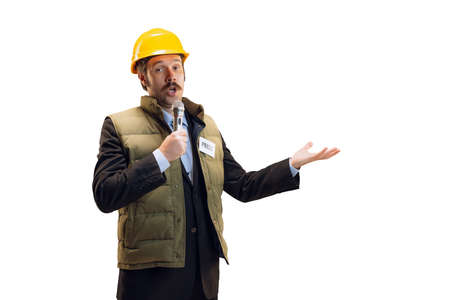 Portrait of young man in helmet, professional commentator, journalist with microphone broadcasting...