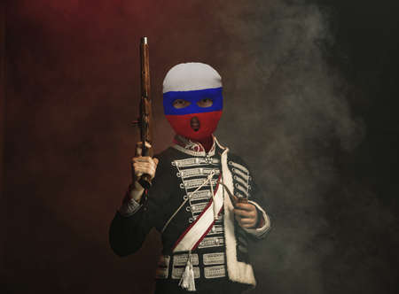 Duel challenge. Young man, art character in vintage outfit and balaclava on dark background. Concept...
