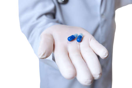 Close-up male hand in protect glove holding pills isolated on white studio background. Concept of...