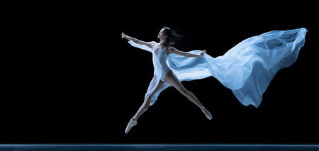 Graceful classic ballerina dancing with weightless fabric isolated on black studio background in neon. Theater, art, beauty, grace, action and motion concept.の写真素材