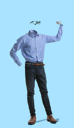Portrait of invisible man wearing modern business style outfit holding cup against blue background....