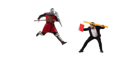 Creative collage. Fight between modern business man and medieval knight wearing armored clothes isolated on white background. Concept of eras comparisonの写真素材