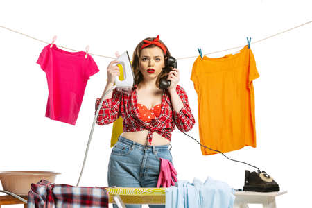 Laundry, cleaning, ironing. Beautiful housewife doing housework isolated on white studio background. Work, emotions, female rights, beauty, familyの写真素材