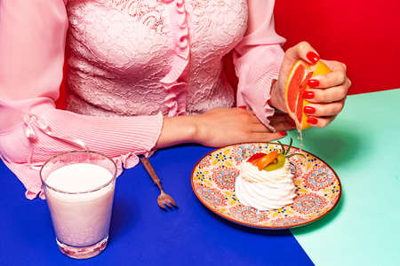 Food pop art photography. Cropped portrait of woman tasting sweet cake with grapefruit on bright...