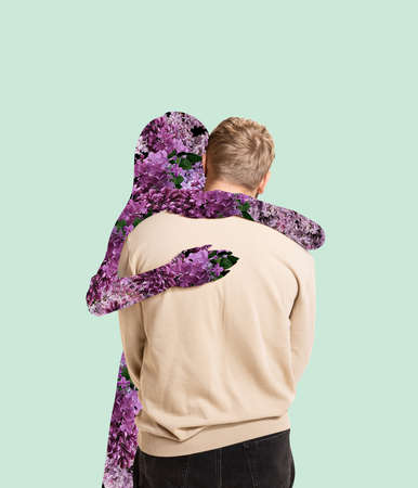 Contemporary art collage. Man hugging silhouette of woman filled with lovely flowers isolated over mint backgroundの写真素材