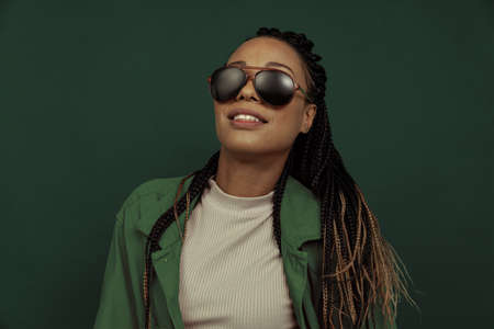 Monochrome portrait of female fashion model in shorts and shirt isolated on dark green background. Concept of beauty, art, fashion, youth and emotionsの写真素材