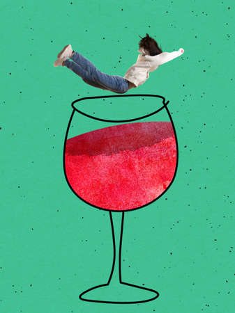 Contemporary art collage. Young woman falling into drawn glass of wine isolated over green backgroundの写真素材