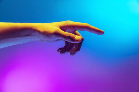 Studio shot of aethentic human hand isolated on gradient purple-blue background in neon light....