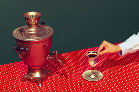 Colorful bright image of old-fashioned kettle called samovar isolated over dark green background.の写真素材