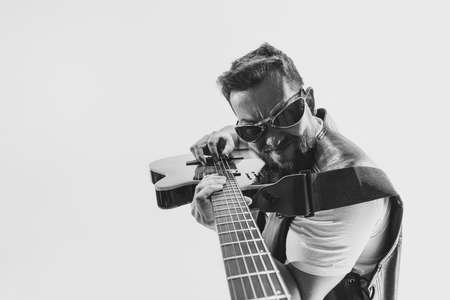 Solo performance Black and white portrait of stylish rock musician with electric guitar isolated on white background. Concept of art, music, styleの写真素材