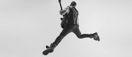 Monochrome. Portrait of stylish young man, rock musician playing electric guitar isolated on white background. Concept of art, music, styleの写真素材