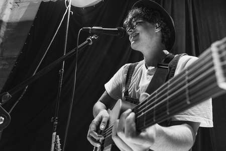 Repetition of retro music band at music studio. Young musician playing acoustic guitar and singing. Rehearsal base. Concept of art, music, style and creationの写真素材