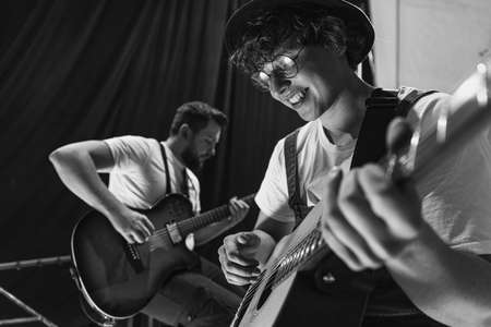 Repetition of rock music band at music studio. Cropped image of electric and acoustic guitar players at concert. Rehearsal base Concept of art, music, styleの写真素材