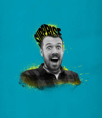 Young excited man with lettering surprise on his head isolated on blue background. Concept of...