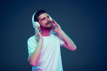 Handsome caucasian mans portrait isolated on dark blue studio background, Concept of human emotions,...