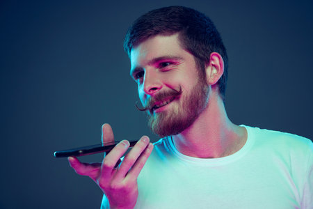 Handsome caucasian mans portrait isolated on dark blue studio background, Concept of human emotions, facial expression, sales, ad, fashion and beautyの写真素材