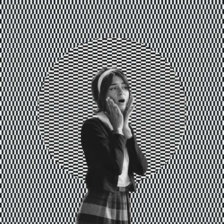Young surprised woman over black and white optical illusion design background. Optical illusion,...