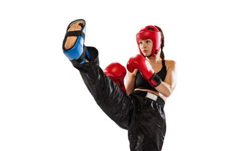 Close-up female boxer in boxing gloves and helmet training isolated on white studio background....