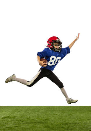 Athletic kid, beginner american football player in sports uniform and helmet training isolated on white background. Concept of sport, challenges, motion, achievements.の写真素材