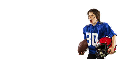 Athletic kid, beginner american football player in sports uniform and helmet training isolated on...
