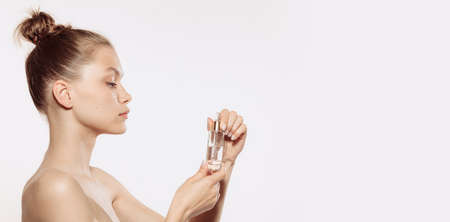 Flyer. Young female fashion model without makeup using rejuvenating face mask isolated on white...