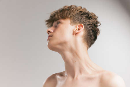 Closeup young man, teen isolated on grey studio background. Concept of teenage skin care, health, cosmetics for problem skin, youthの写真素材