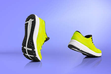 Strolling sports shoes on lilac color background. Sneakers or trainers isolated. Athletic shoes. fitness, sport, training concept. Urban fashionの写真素材