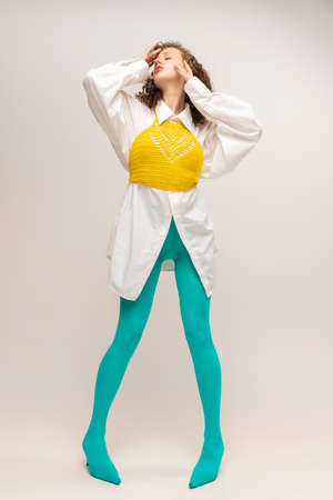 Contemporary art portrait of young emotional girl in bright cyanic tights isolated over white background. Vivid style, beauty, queer, freak, fashion concept.の写真素材