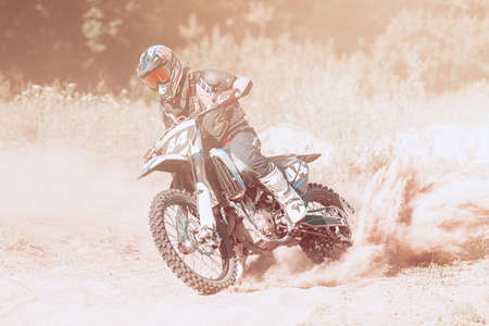 Live shot of male sportsman training on motorbike at hot summer day, outdoors. Motocross rider in...
