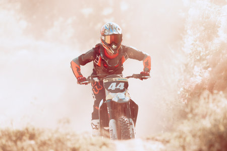 Professional motorcycle rider training on Enduro motorcycle at steppe or desert area, outdoors at hot summer day.のeditorial素材