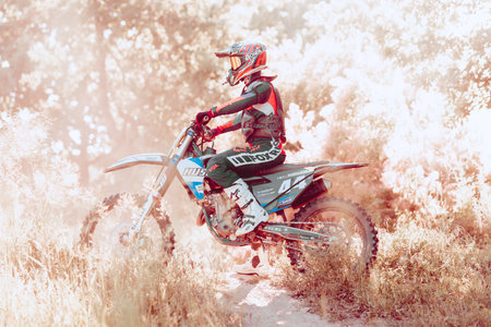 Live shot of professional motorcycle rider training on Enduro motorcycle at steppe or desert area, outdoors at hot summer day.のeditorial素材